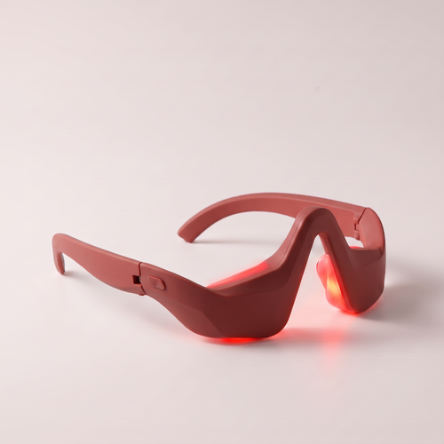 Hands-free eye massager in brick red with red light on